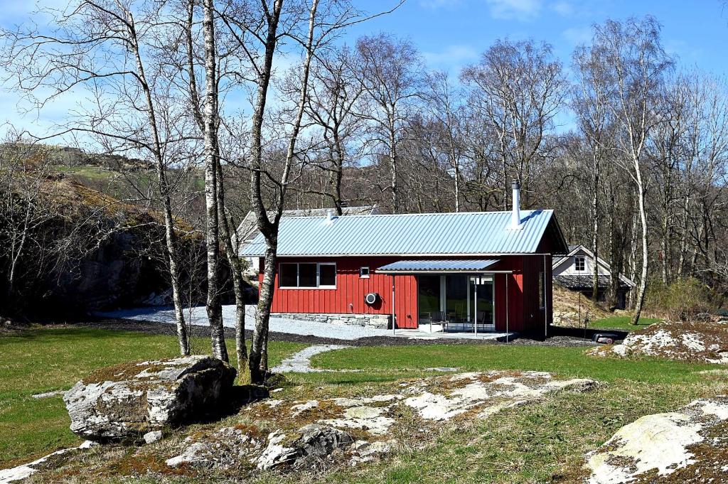 a red cabin in the middle of a field at Østhusvik Cabin in Stavanger