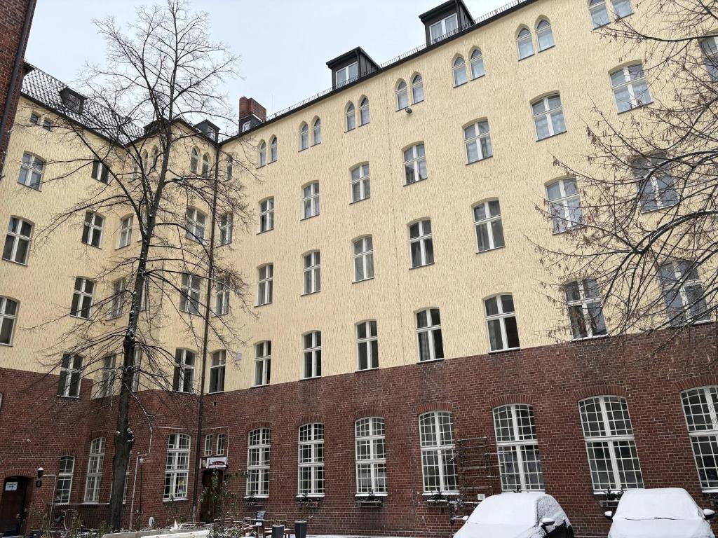 a large brick building with snowcovered cars in front of it at Haus St Vinzenz in Berlin