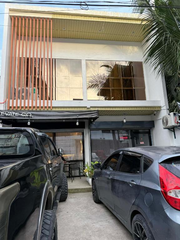 two cars parked in front of a building at Berchby Loft in Digos
