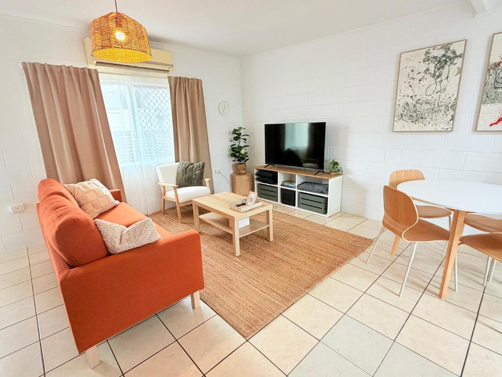 a living room with a orange couch and a table at 'Your Place on Davidson' Uno in Mount Isa