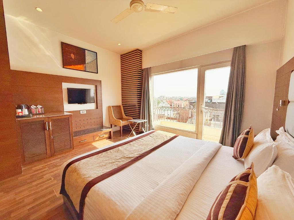 a hotel room with a large bed and a large window at Sawera Grand Luxury Stay Near Golden Temple in Amritsar