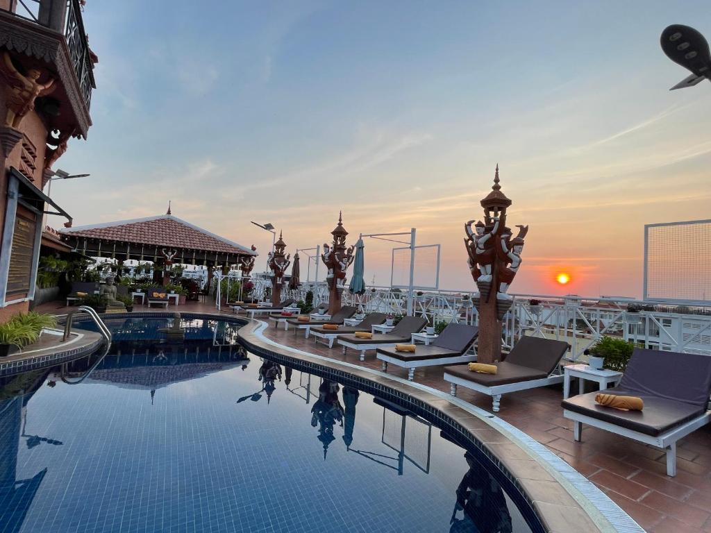 a pool on the roof of a building with lounge chairs at Okay 1 Villa in Siem Reap