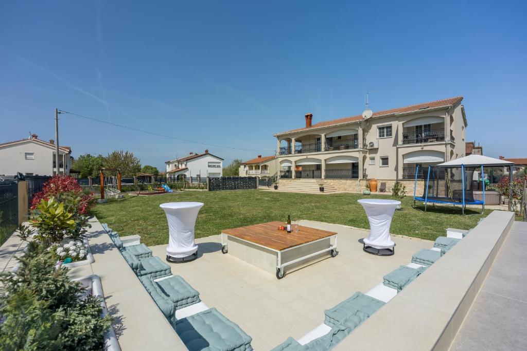 a patio with a table and chairs and a house at Apartments Covic in Antonci