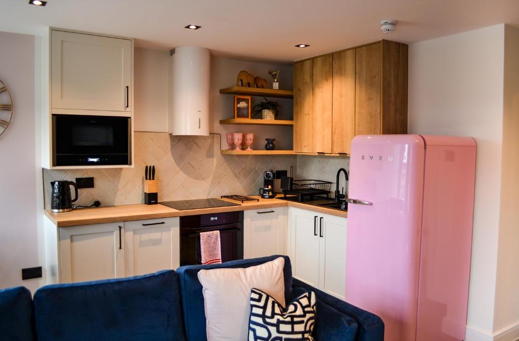 a kitchen with a blue couch and a pink refrigerator at Royal Six Apartments in Harrogate