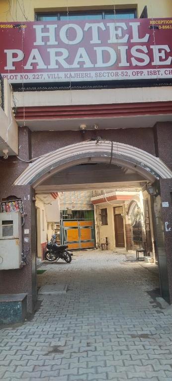 an entrance to a parking garage with a motorcycle under a sign at Hotel Paradise in Chandīgarh