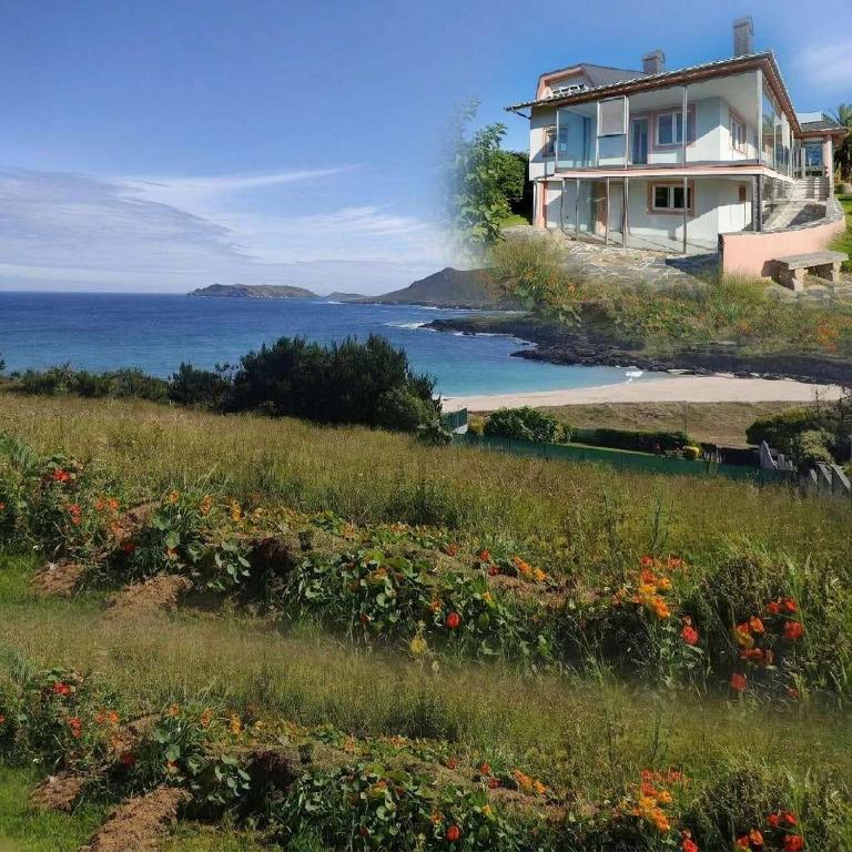 a house on a hill next to the ocean at Casa completa - Camiño dos faros - Atlantico Malpica in Malpica
