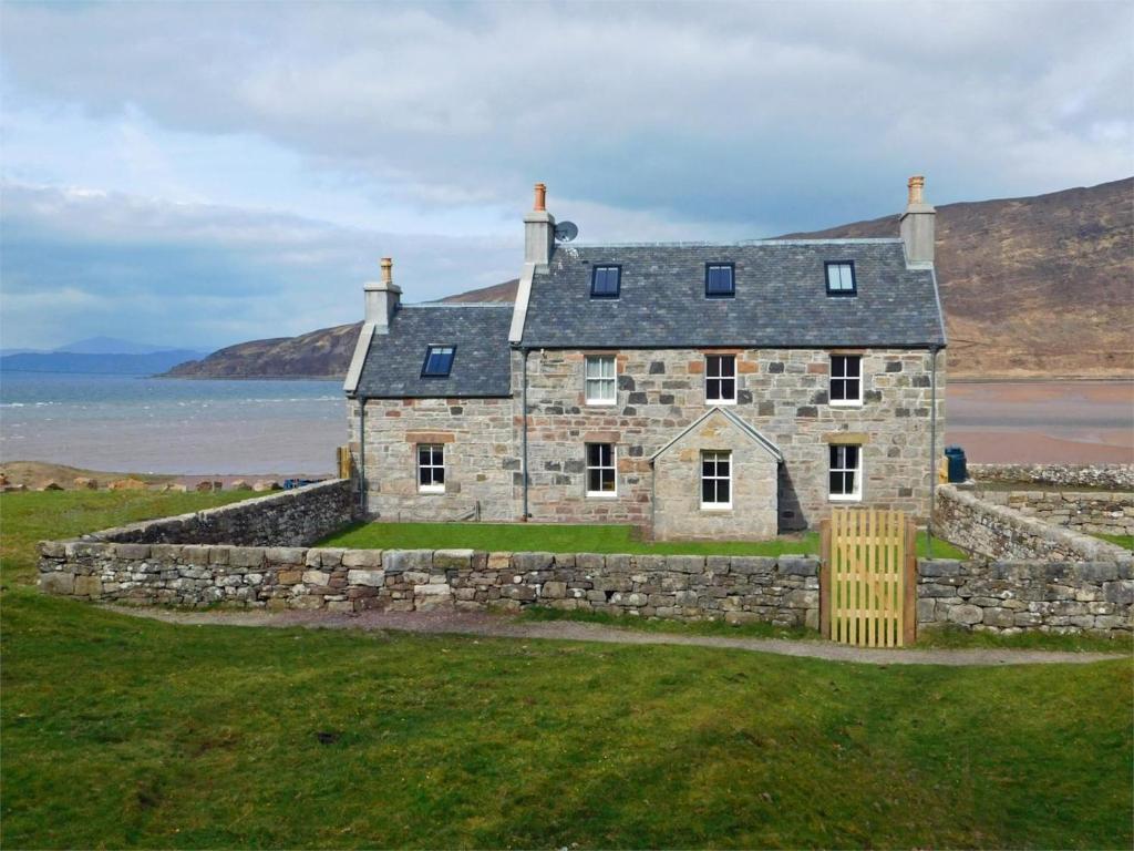 an old stone house on the shore of the ocean at 6 Bed in Strathcarron oc-ca343 in Applecross