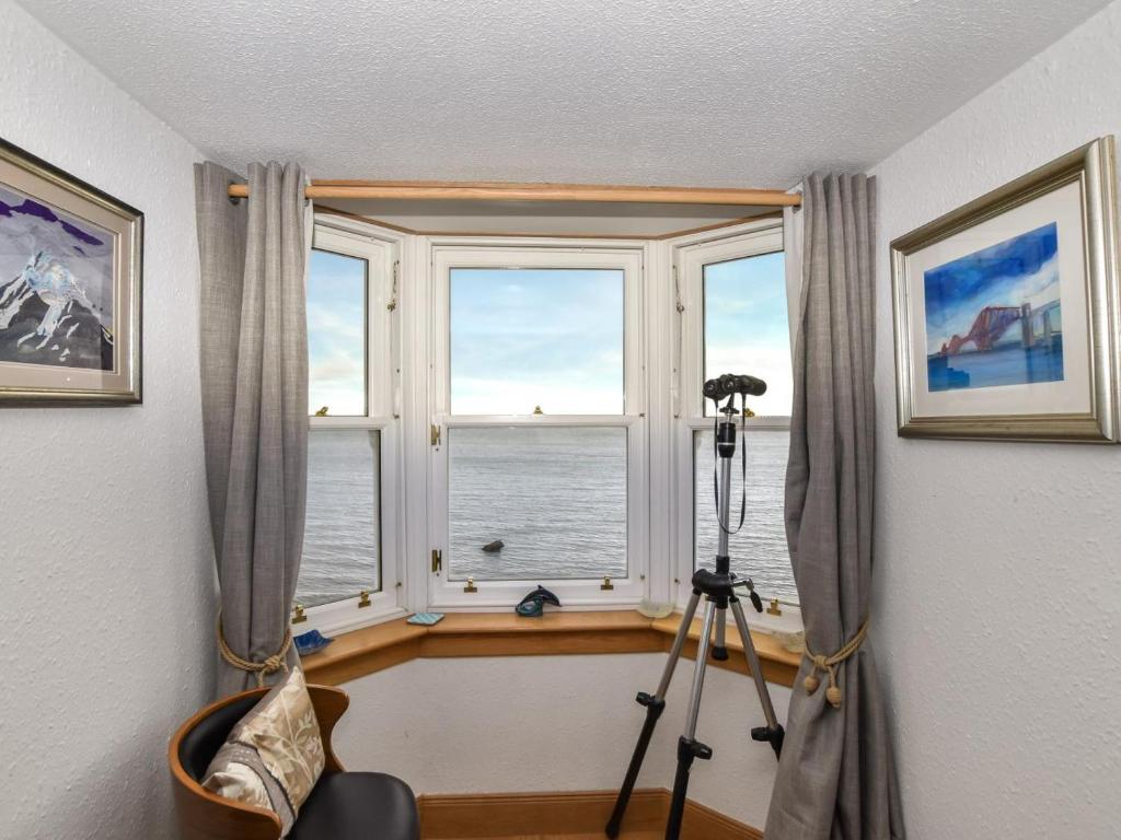 a camera in front of a window with a view of the ocean at 1 Bed in Burntisland oc-47388 in Kinghorn