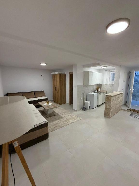 a large living room with a bed and a kitchen at Apartmani ,,Merlin,, in Utjeha
