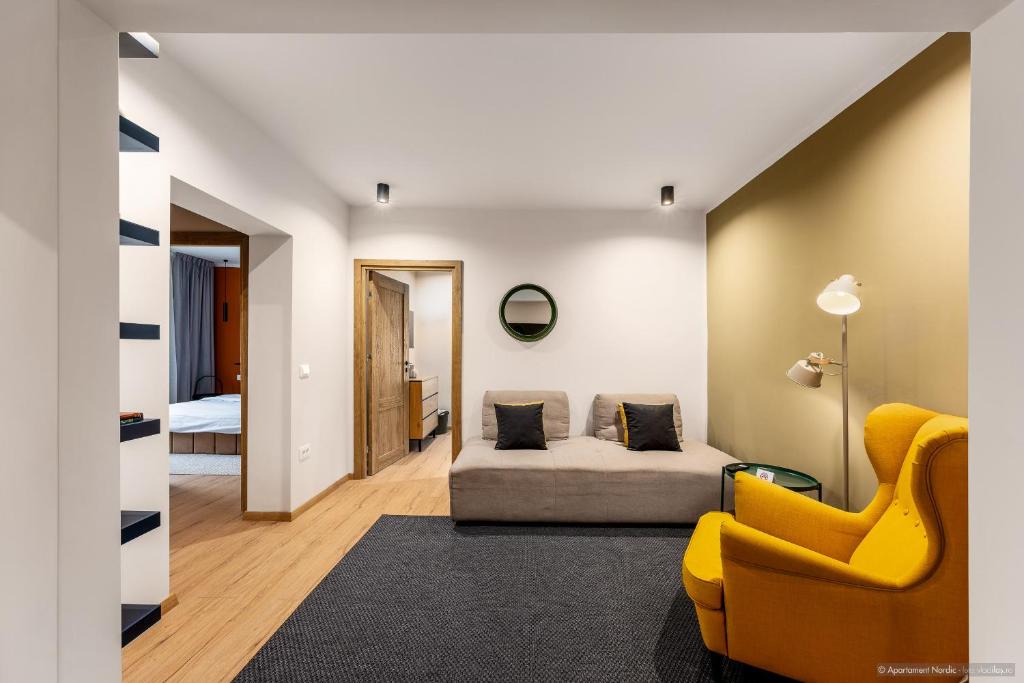 a living room with a couch and a yellow chair at Apartament Nordic 3 in Gura Humorului