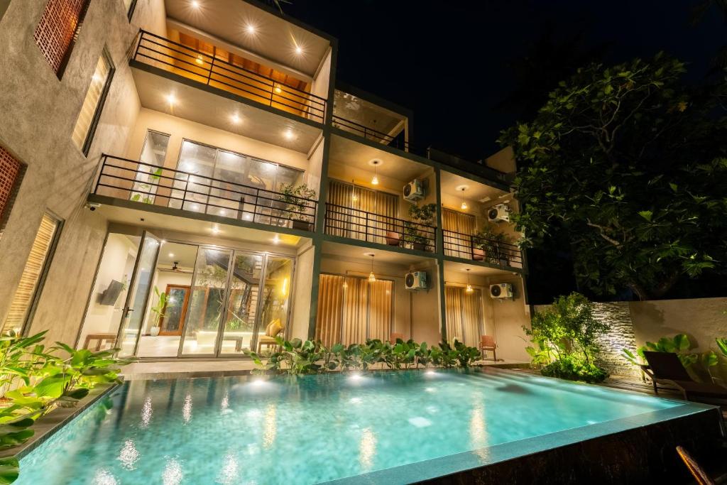 a house with a swimming pool in front of it at Aqualuna Weligama in Weligama