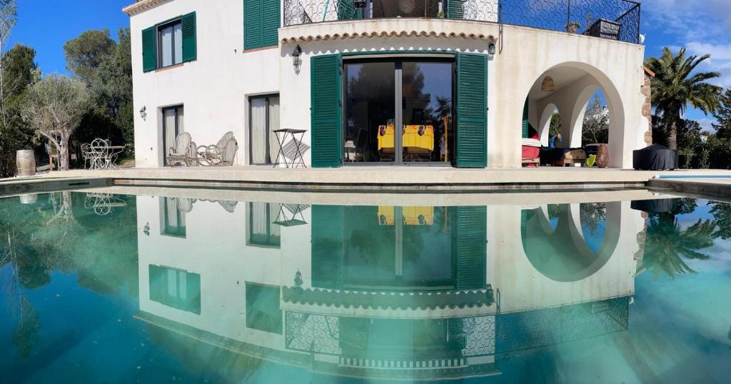 a villa with a swimming pool in front of a house at La Maison du Bonheur in Saint-Raphaël