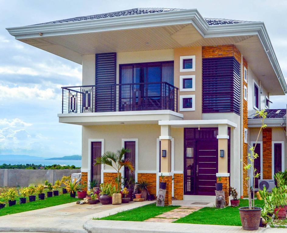 a house with a porch and a balcony at Bohol Ramyer Villa in Totolan