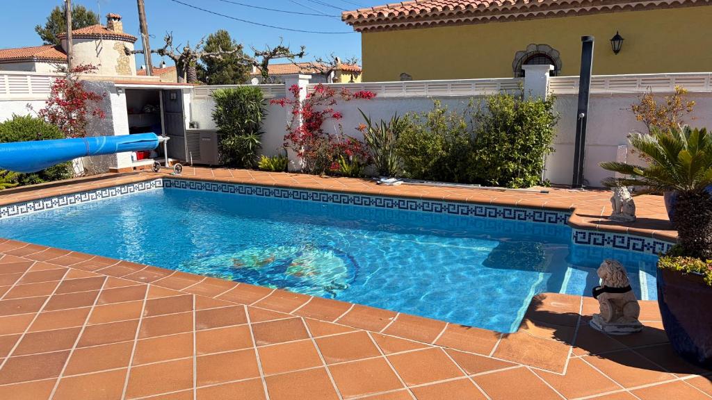 a swimming pool in front of a house at MEDDAYS Villa CARMEN in Miami Platja
