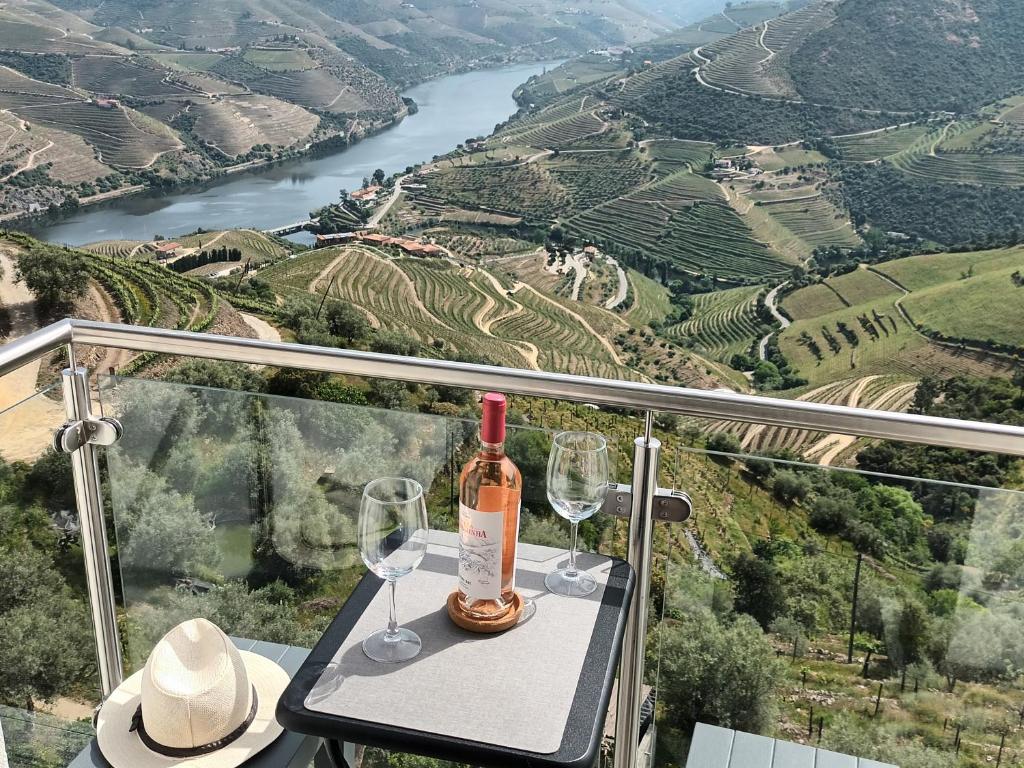 a bottle of wine sitting on a table with wine glasses at Panorama Douro House in Armamar