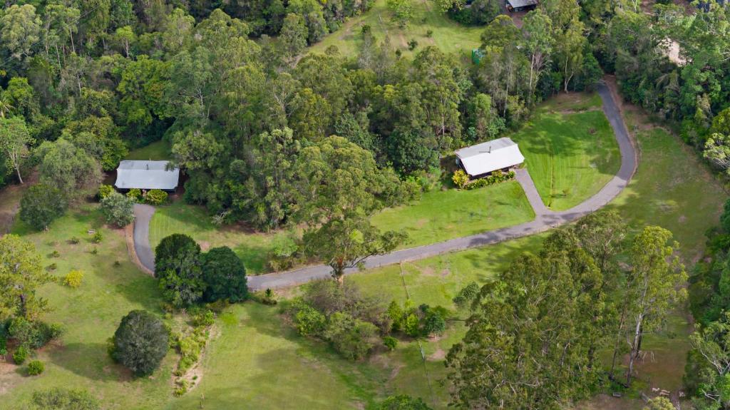 an aerial view of a road in a forest at Starry Nights Luxury Camping in Woombye
