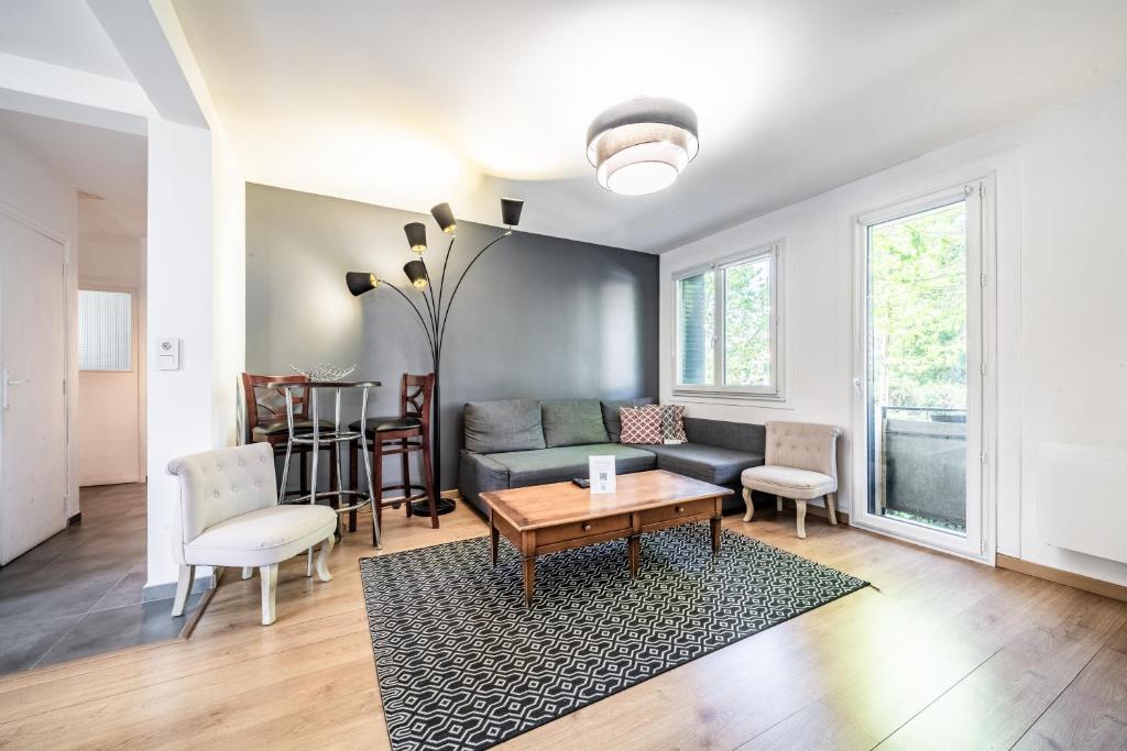 a living room with a couch and a table at Appartement Cosy Parc Thermal in Thonon-les-Bains