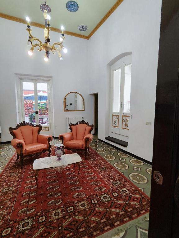 a living room with two chairs and a table on a rug at B&B Palazzo Antonelli in Monopoli