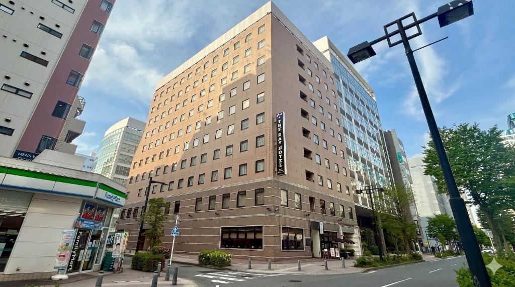 a tall brown building on a city street at THE DAY HOTEL ShinYokohama in Yokohama