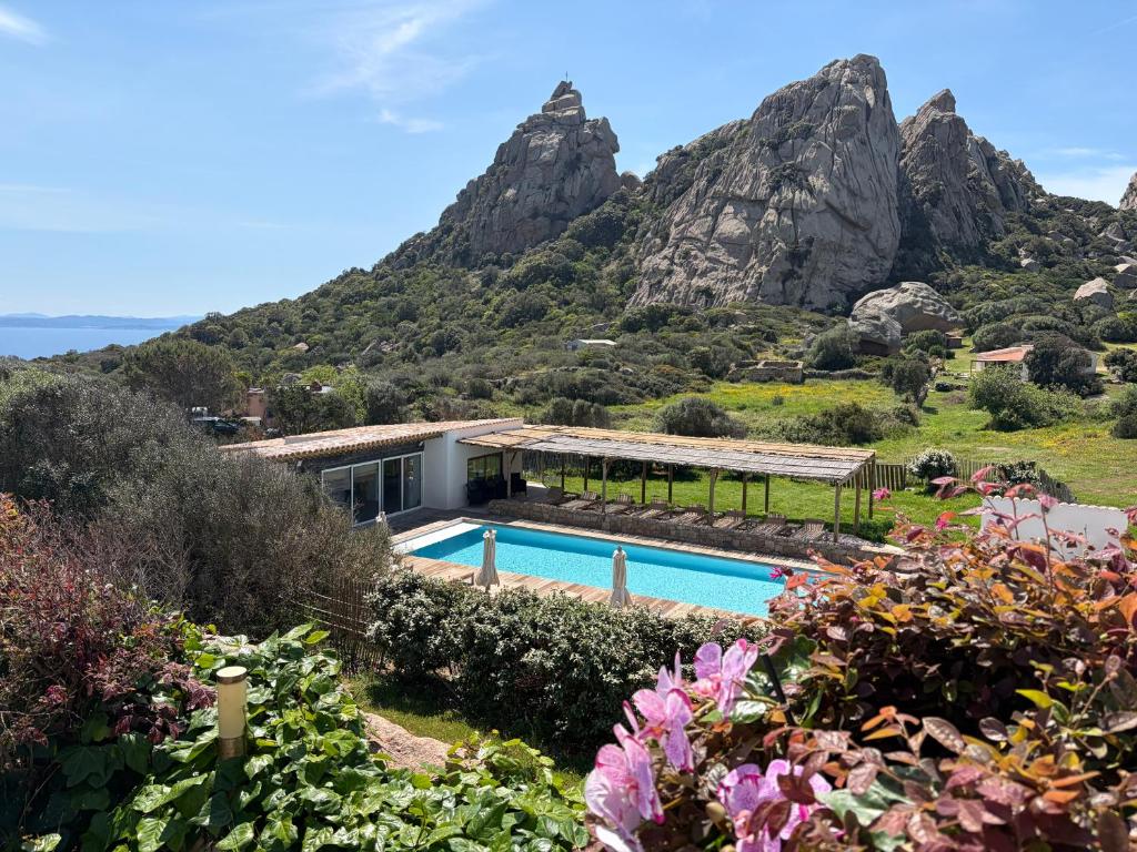 a villa with a swimming pool in front of a mountain at A Santa Trinita in Bonifacio