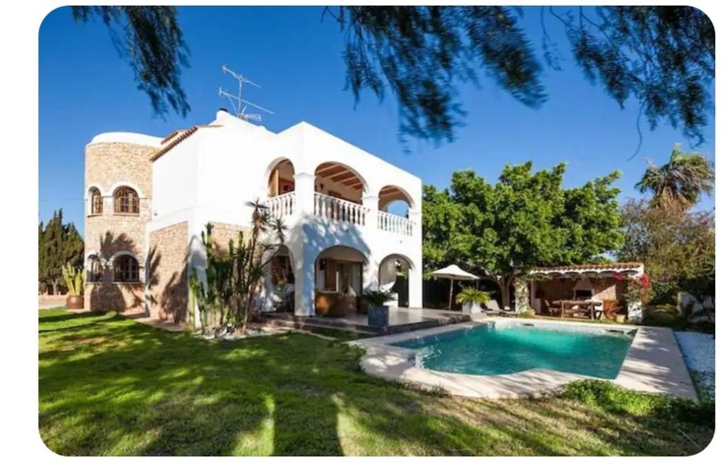 a large white house with a swimming pool at La Vijanera in Sant Jordi