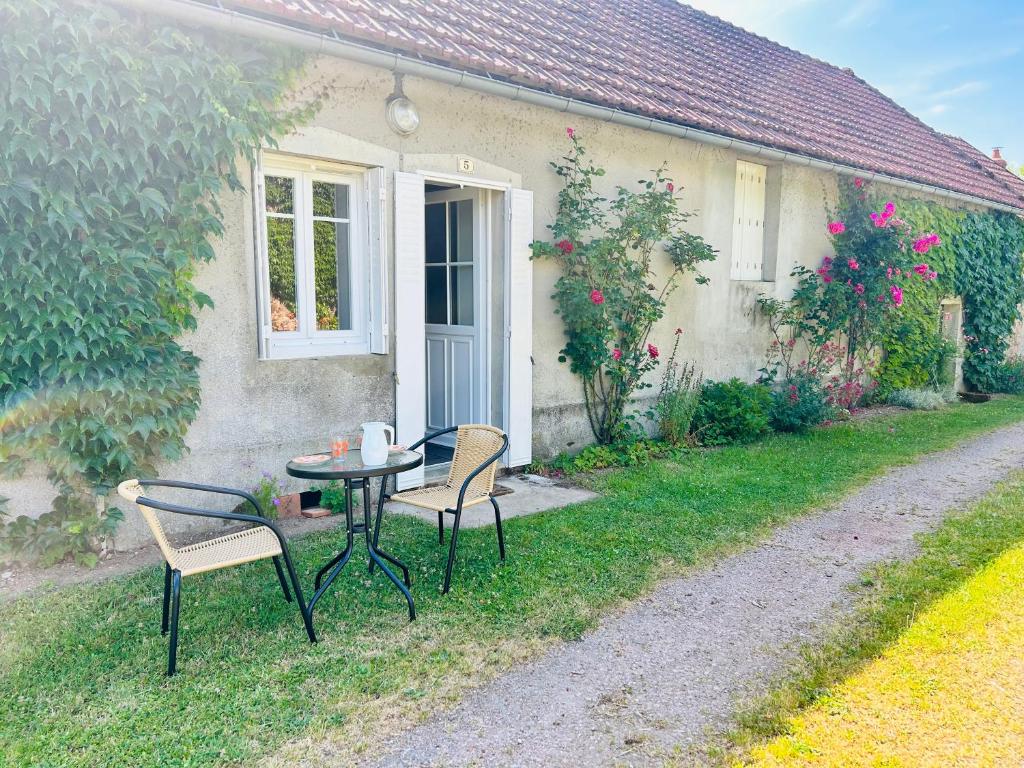 a table and chairs in front of a house at La maisonnette du Morvan in Cussy-en-Morvan