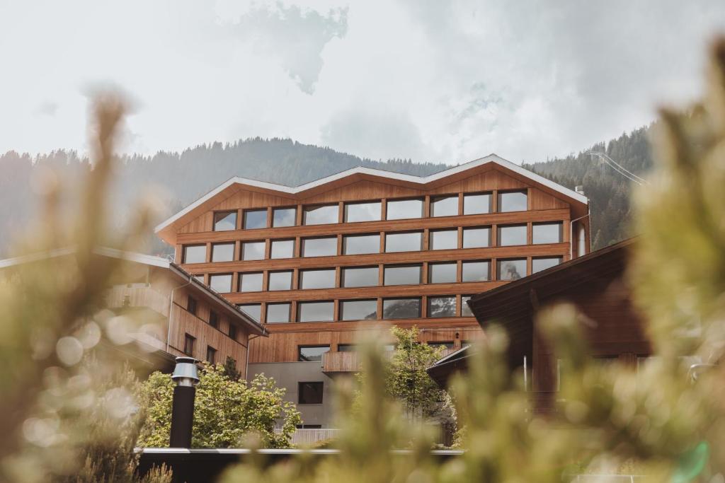 a large office building with a mountain in the background at Revier Mountain Lodge Adelboden in Adelboden