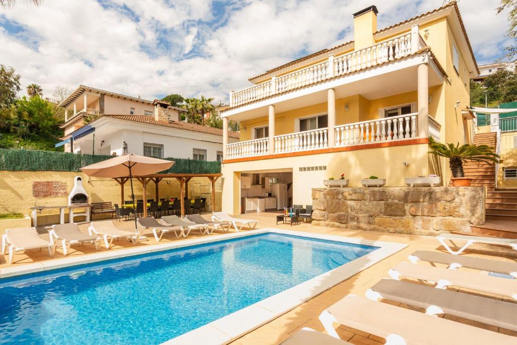 a villa with a swimming pool and a house at Villa Florida in Lloret de Mar