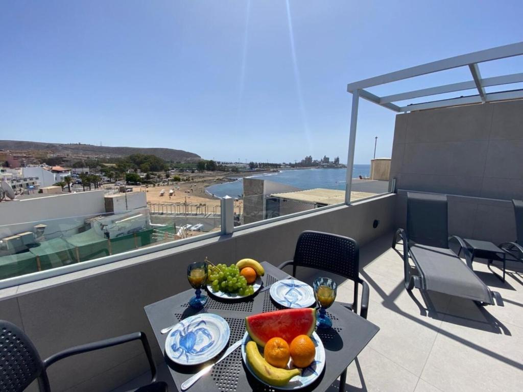 a table with a bowl of fruit on a balcony at Alaram Holidays House by Villas Rivero in Arguineguín