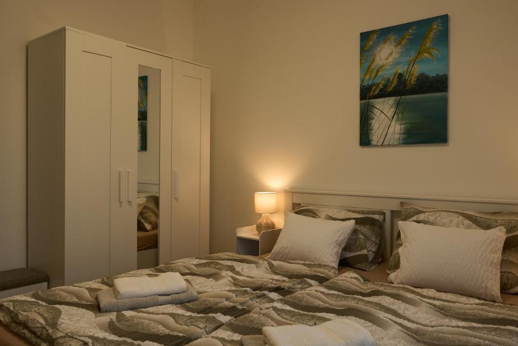 a bedroom with a large bed with two pillows at Netto Apartman in Fonyód