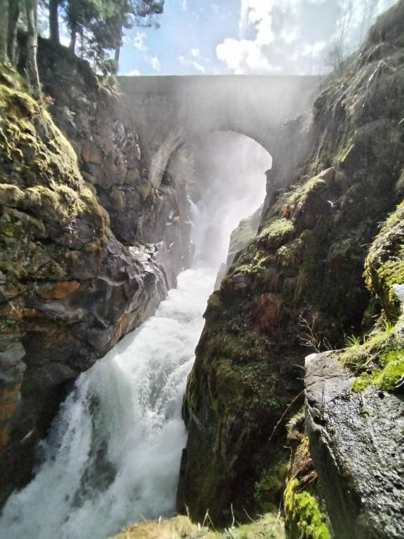 a waterfall in the middle of a rocky canyon at Douce Altitudes Cauterets in Cauterets