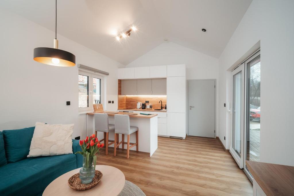 a living room and kitchen with a couch and a table at Domeček U Potoka in České Budějovice