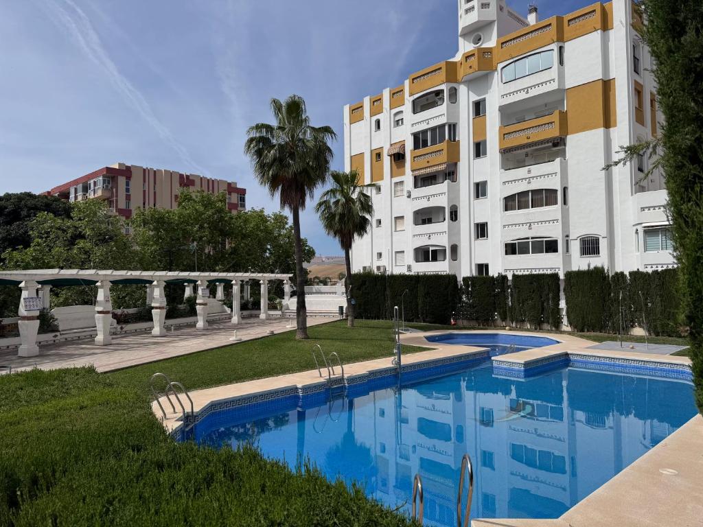 a building with a swimming pool in front of a building at Spacious Apartment with 3 pools very central in Benalmádena