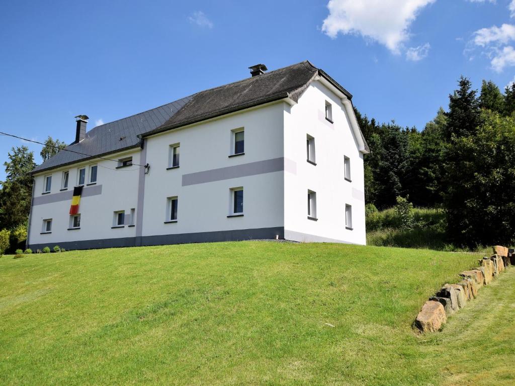 a large white building on a grassy hill at Holiday Home in Saint Vith with Terrace in Schoenberg