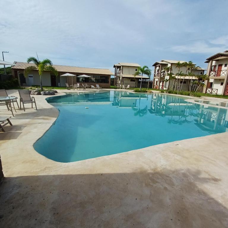 a large pool with blue water in a resort at Kite House Lençóis II in Santo Amaro