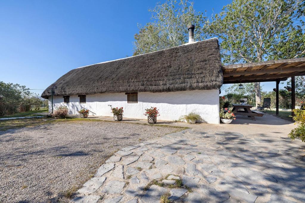 a large white building with a thatched roof at La Barraca den Salvador in Deltebre