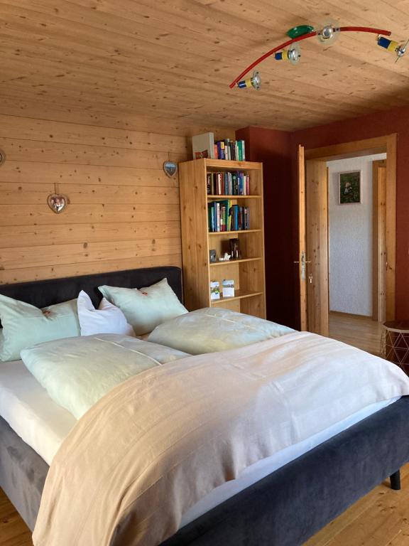 a bedroom with a large bed with a book shelf at Sissy Appartment in Kössen