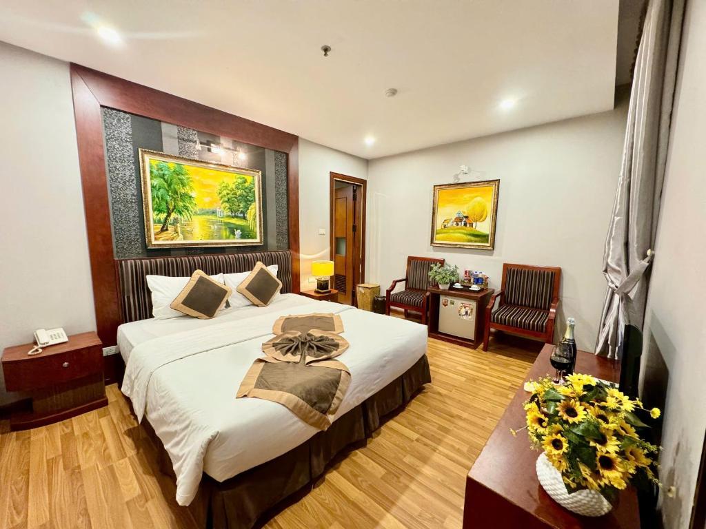 a hotel room with a large bed and a desk at Gllant Villa Hà Nội in Hanoi