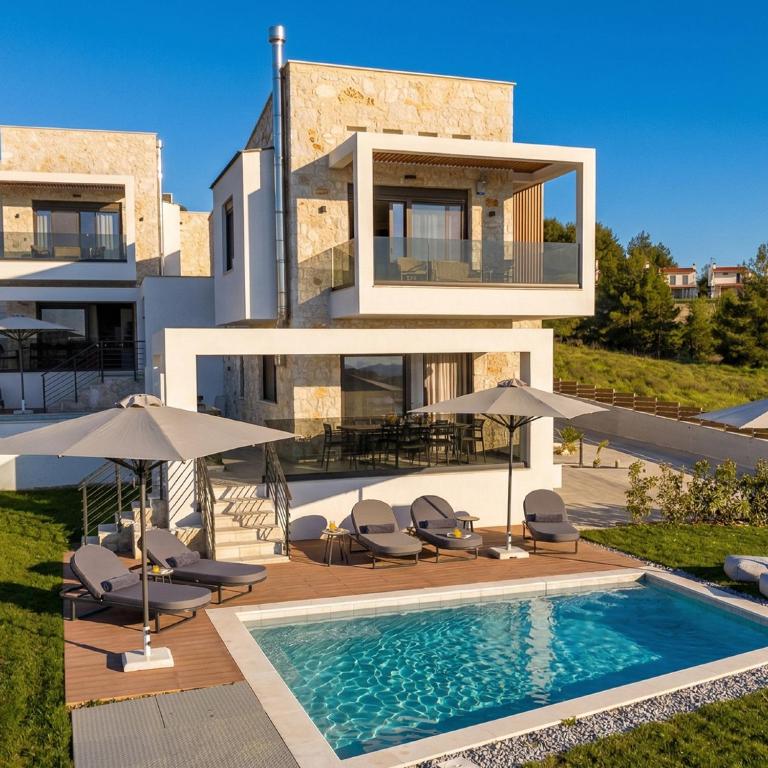 a villa with a swimming pool and umbrellas at The Four Villas Hanioti by Luxlikehome in Hanioti
