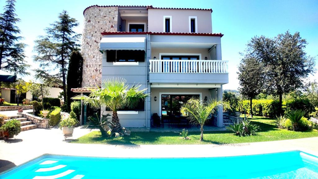 a house with a swimming pool in front of it at Villa Arena Theologos in Theologos