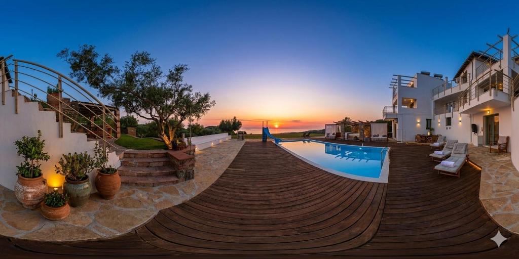 a swimming pool with a sunset in the background at Villa Freebird - VIP Wedding & Bachelor Events in Pefkochori