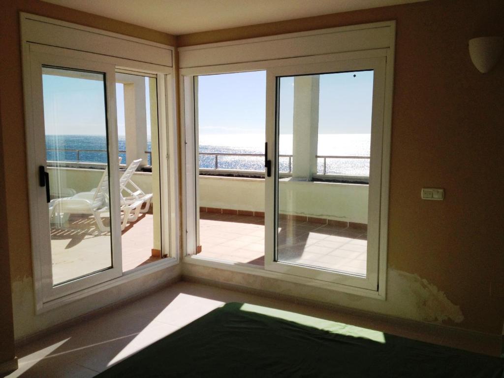 a room with windows with a view of the ocean at Ático Ancla in L'Ametlla de Mar