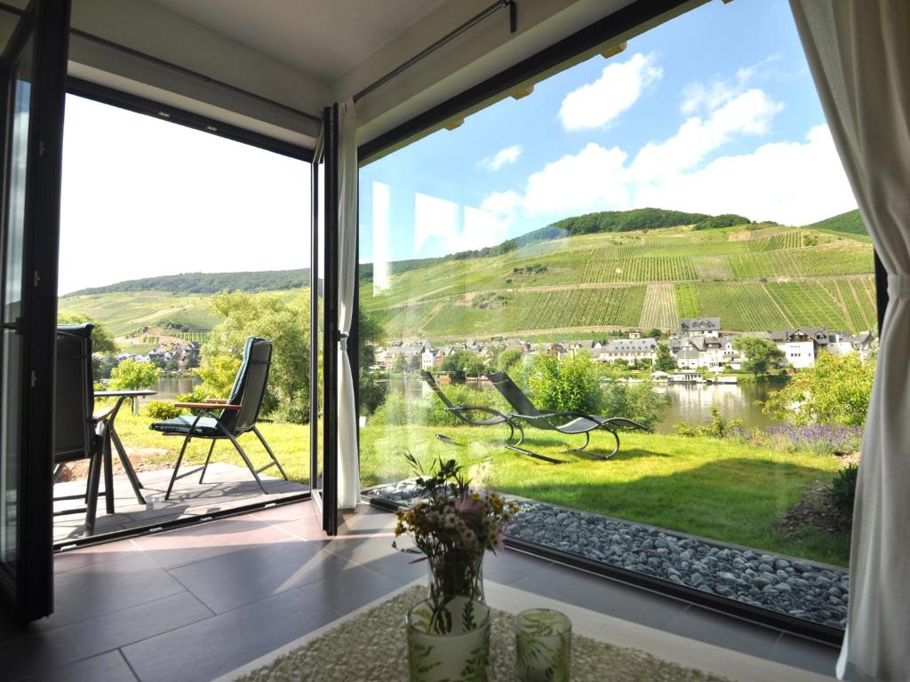 a room with a large window looking out at a vineyard at Ferienwohnung Moselufer Zell in Zell an der Mosel