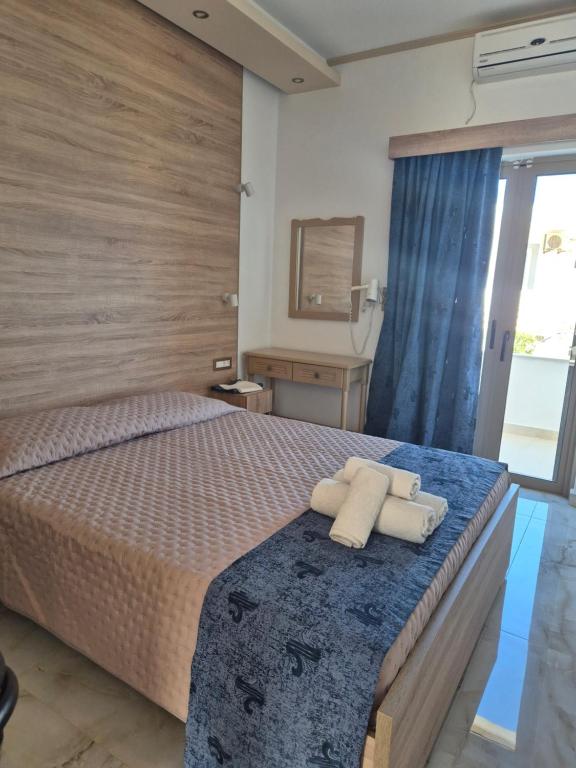 a bedroom with a bed with two towels on it at Christina Studios in Kefalos