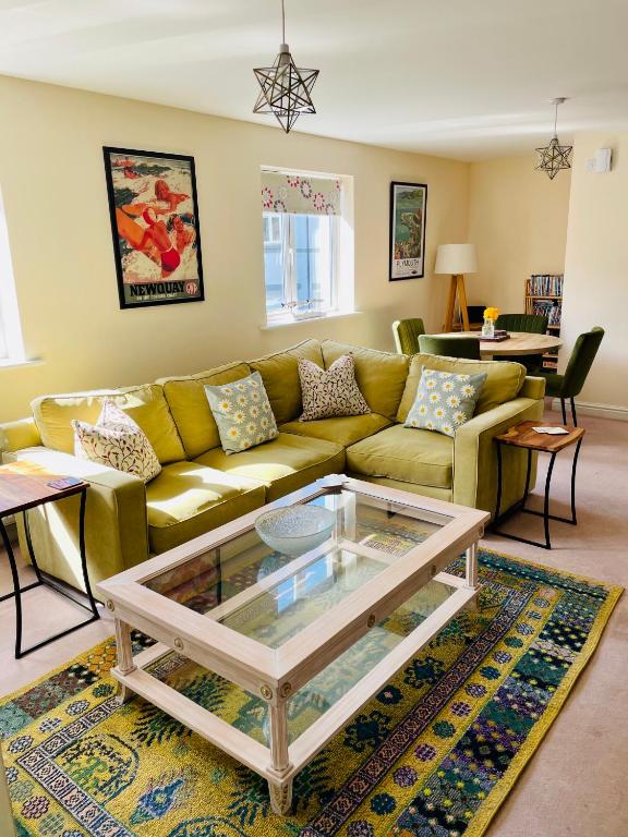 a living room with a couch and a glass table at The Coach House in Par