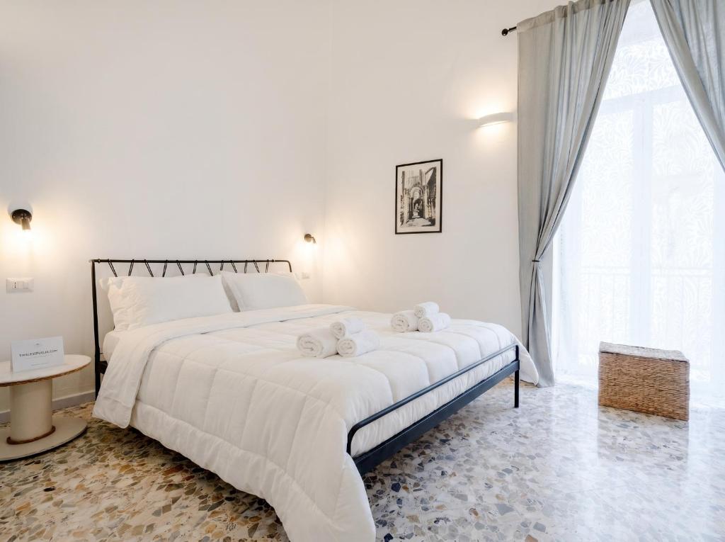 a white bedroom with a large bed with towels on it at Andromeda in Modugno
