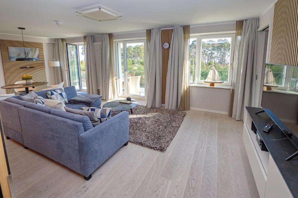 a living room with a blue couch and a tv at Strandresort Prora - Wohnung 213 in Binz