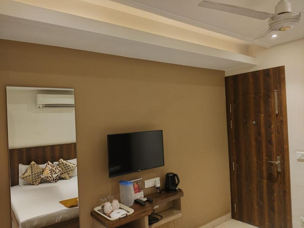 a hotel room with a bed and a flat screen tv at Eennra Kaansabbati in Medinīpur
