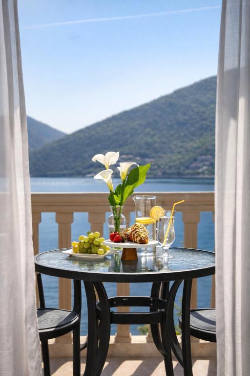 a table with a plate of food on a balcony at Apartments Stella del Mare in Risan