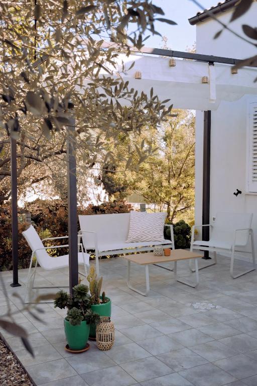 a patio with two white chairs and a table at Casa Verde Oliva - WelcHome in Rocca San Giovanni